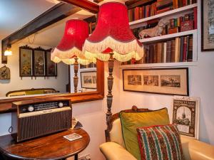 sala de estar con mesa y lámpara de araña en Finest Retreats - Lychgate Cottage en Mattishall