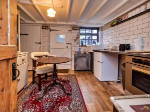 a kitchen with a table and a stool in it at Finest Retreats - Lychgate Cottage in Mattishall