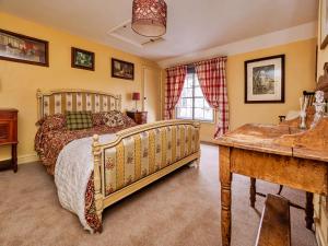 - une chambre avec un lit et un bureau dans l'établissement Finest Retreats - Lychgate Cottage, à Mattishall