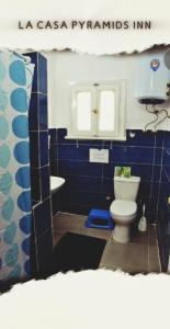 a blue bathroom with a toilet and a sink at La Casa pyramids Inn in Cairo