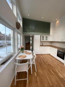 cocina con armarios blancos, mesa y sillas en Ett nytt fräsch hus utanför Stockholm nära Arlanda en Rosersberg