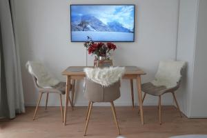 een eettafel met 2 stoelen en een vaas met bloemen bij Bergblick 411 am Wolfgangsee in Strobl