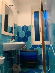 baño con lavabo y pared de azulejos azules en Casa Bella 'Mbriana, en Rio Marina
