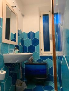 a bathroom with a sink and a blue tiled wall at Casa Bella 'Mbriana in Rio Marina +45 photos