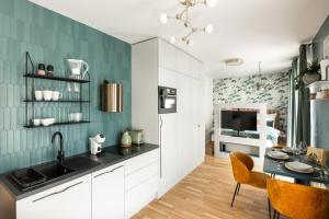 eine Küche mit weißen Schränken und grünen Wänden in der Unterkunft Prague Bohemian Rhapsody Suites in Prag