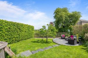 a garden with chairs and a tree at Luxury self-contained cottage for two with hot tub in Staverton