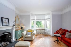 sala de estar con chimenea y sofá rojo en Phoenix Rise Retreat, en Glastonbury