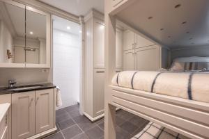 uma pequena cozinha com uma cama e um lavatório em 3e verdiep Appartement op zeedijk in Knokke voor 7 personen em Knokke-Heist