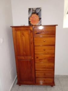 a wooden dresser with a flower on top of it at Maison charmante au cœur de Le Gosier avec cheminée in Le Gosier