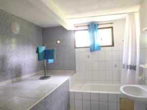 a bathroom with a bath tub and a sink at Maison charmante au cœur de Le Gosier avec cheminée in Le Gosier
