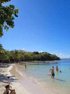 a group of people playing in the water on a beach at Maison charmante au cœur de Le Gosier avec cheminée in Le Gosier +5 photos