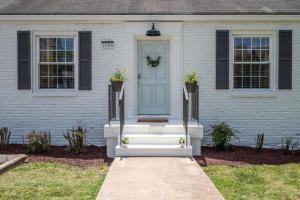 een huis met een blauwe deur met twee potplanten bij Charming Home with 4 Bedroom 6 Beds in Hillsboro Village in Nashville