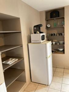 eine Küche mit einer Mikrowelle auf dem Kühlschrank in der Unterkunft Cholet 500m du cormier 15 min du puy du fou in Cholet