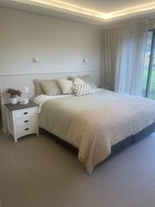 a bedroom with a large bed and a night stand at Mountain Views, Remarkable in Queenstown