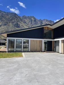 a large building with mountains in the background at Mountain Views, Remarkable in Queenstown