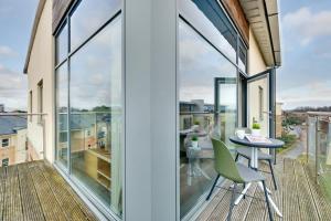uma varanda com portas de vidro e uma mesa e cadeiras em Fenwick Chambers by Week2Week em Gosforth