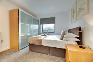 um quarto com uma cama grande e uma cabina de duche em vidro em Fenwick Chambers by Week2Week em Gosforth