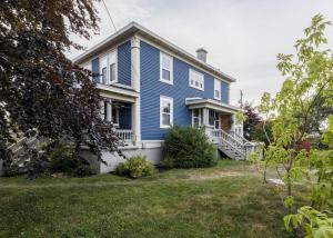una casa azul con porche y patio en Duff Heritage House, en St. John's