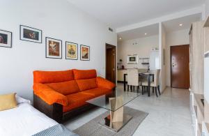 sala de estar con sofá naranja y mesa de cristal en LuxSevilla Moderno 1 Room Piscina Parking, en Bormujos