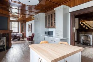 a kitchen with white cabinets and a fireplace at Duff Heritage House in St. John's