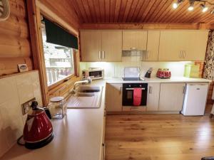 eine Küche mit weißen Geräten und Holzschränken in der Unterkunft The Great Escape in Louth