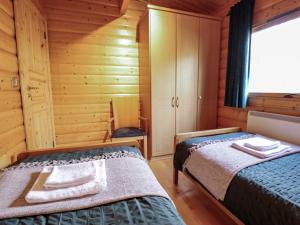 a bedroom with two beds in a wooden cabin at The Great Escape in Louth