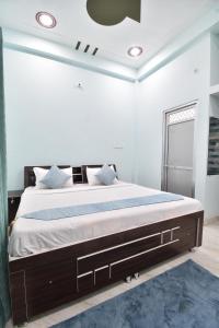 - une chambre avec un grand lit et un tapis bleu dans l'établissement Hotel Ramayan Inn Free Pickup From Ayodhya Dham Junction, à Ayodhya