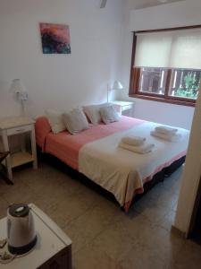 1 dormitorio con 1 cama con toallas en Hotel Barracuda en Villa Gesell