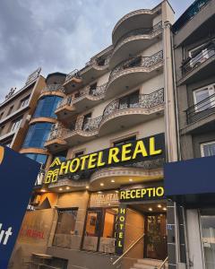 un cartello di noleggio hotel sul lato di un edificio di Hotel Real a Pristina