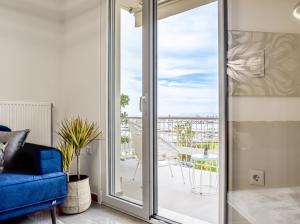 sala de estar con sofá azul y puerta corredera de cristal en Two Bedroom Sea View Apartment in Glyfada Beach, en Atenas