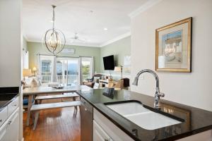 a kitchen with a sink and a living room at 93 Waters Edge - Townhome - Pool in Folly Beach