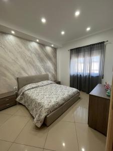 a bedroom with a bed and a wall at Casa vacanza Helios in Leonforte +35 photos