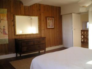 um quarto com uma cama e uma cómoda com um espelho em Maison de 3 chambres avec wifi a Fontenay sur Mer em Fontenay-sur-Mer