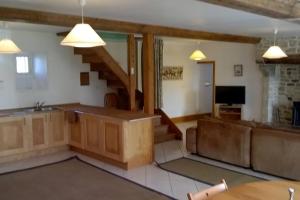 un soggiorno con un divano e una televisione di Maison élégante à Fontenay-sur-Mer avec cheminée a Fontenay-sur-Mer