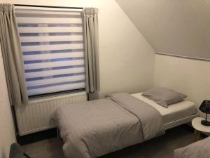 a small bedroom with a bed and a window at Le Montôbuis in Couvin