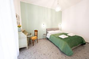 Un dormitorio con una cama, un escritorio y una silla. en Dimora Porcelli, en Bari