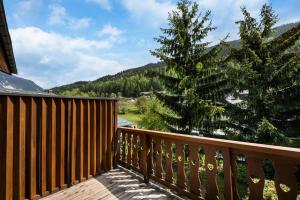 a wooden deck with a pine tree on it at Résidence Roc Mugnier - Chalets pour 8 Personnes 504 in Courchevel