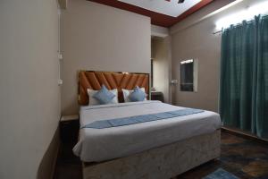 a bedroom with a large bed with a wooden headboard at Hotel Ramayan Inn Free Pickup From Ayodhya Dham Junction in Ayodhya