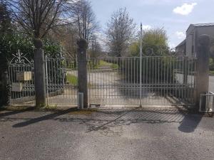 a gate to a house with a driveway at Maison de 2 chambres avec wifi a Gace in Gacé