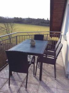 einen schwarzen Tisch und Stühle auf dem Balkon in der Unterkunft Schöne Ferienwohnung am Fuße der Rhön. in Eichenzell