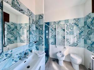 uma casa de banho azul e branca com uma banheira e um WC em Vera Gioia Rooms de Charme em Sorrento