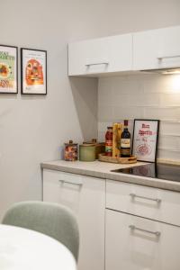 una cocina con armarios blancos y una encimera con especias en Homs Boutique Apartment, en Roma