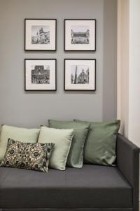 un sofá sentado en una sala de estar con fotos en la pared en Homs Boutique Apartment, en Roma