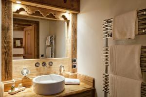 a bathroom with a sink and a large mirror at Résidence Maison Du Praz - Maisons & Villas pour 8 Personnes 494 in Courchevel