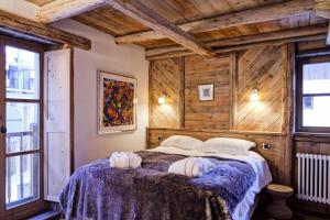 a bedroom with a bed in a room with wooden walls at Résidence Maison Du Praz - Maisons & Villas pour 8 Personnes 494 in Courchevel
