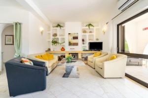 uma sala de estar com dois sofás e uma televisão em Villa Palmeiras - Serene Private Villa em Albufeira