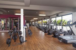 un gimnasio con una fila de cintas de correr y máquinas en Papagayo Beach Resort, en Willemstad