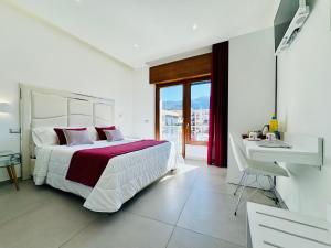 um quarto branco com uma cama grande e uma secretária em Vera Gioia Rooms de Charme em Sorrento