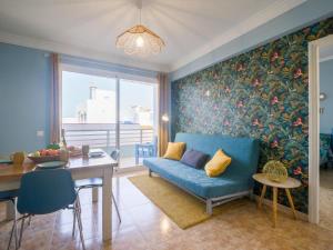 - un salon avec un canapé bleu et une table dans l'établissement Casita Canaria First Line Terrace y Seaside View, à Las Palmas de Gran Canaria