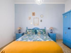 - une chambre avec un lit jaune et des armoires bleues dans l'établissement Casita Canaria First Line Terrace y Seaside View, à Las Palmas de Gran Canaria